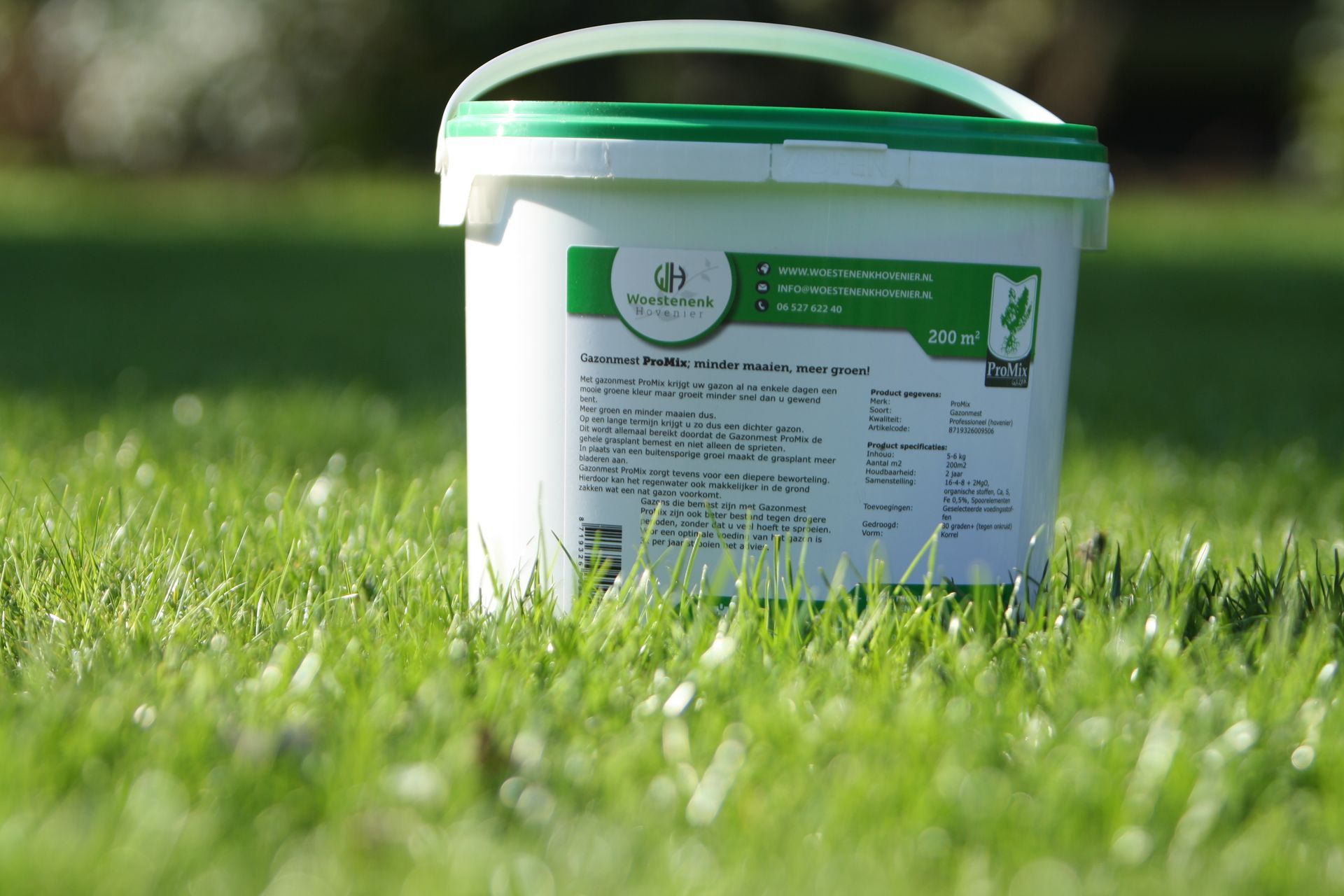Witte container met gazonproduct op groen gras.