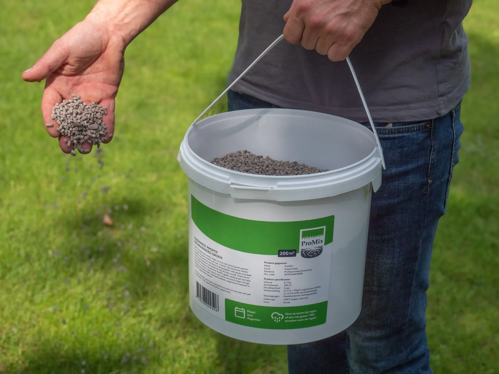 Witte container met gazonproduct op groen gras.