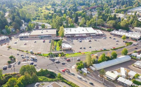 An aerial view of a shopping center surrounded by trees and buildings.
