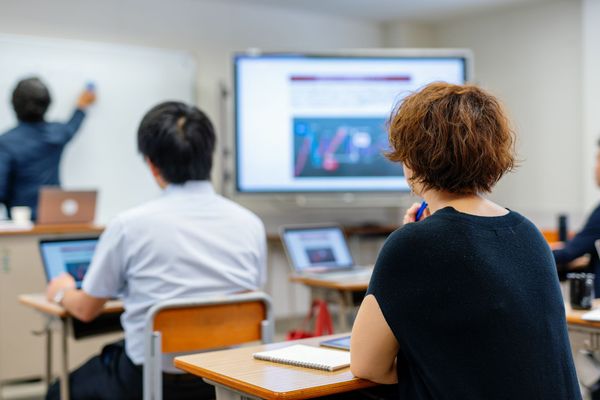 Sessione di formazione in aula con partecipanti che guardano una presentazione su un grande schermo.