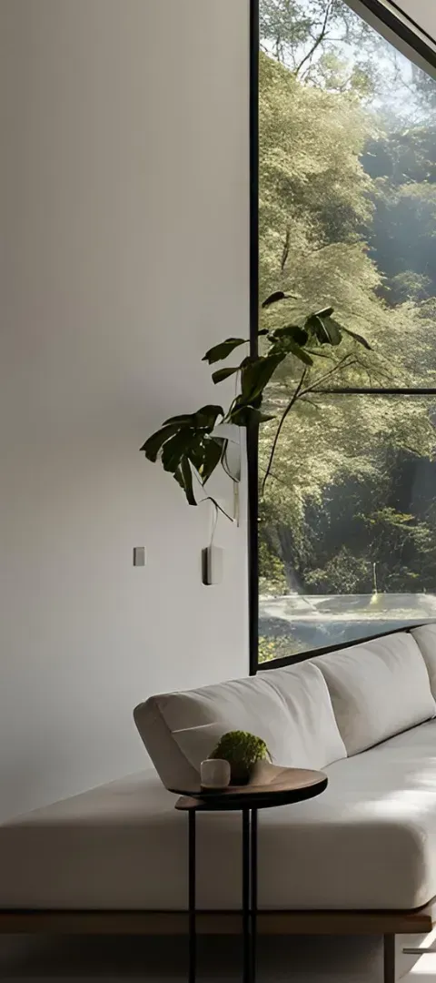 A living room with a couch and a table in front of a large window.