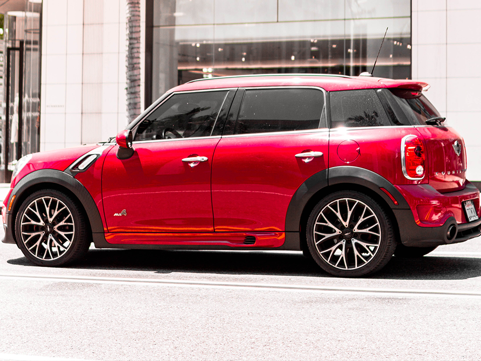 A red mini cooper is parked on the side of the road