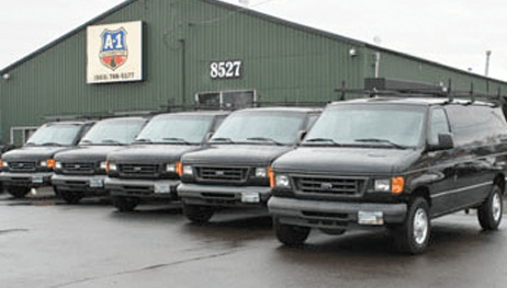 A row of vans are parked in front of a building with the number 8527 on it
