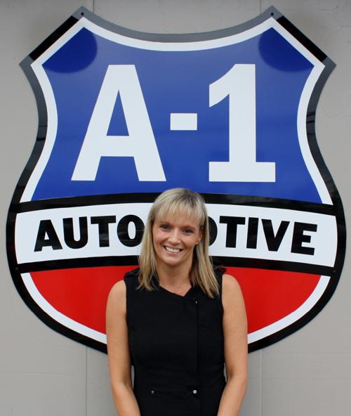 A woman stands in front of a sign that says a-1 automotive
