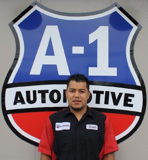 A man stands in front of a sign that says a-1 automotive