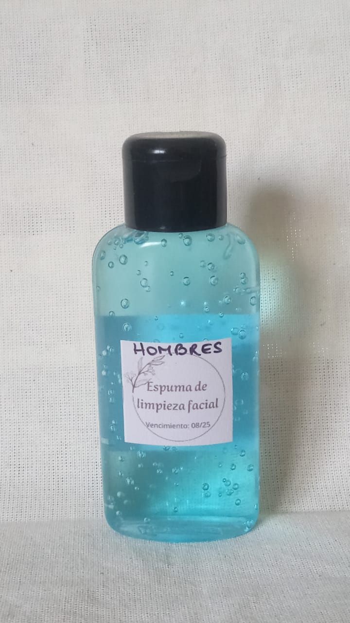 Botella de líquido azul con tapón negro y etiqueta blanca sobre un fondo claro.