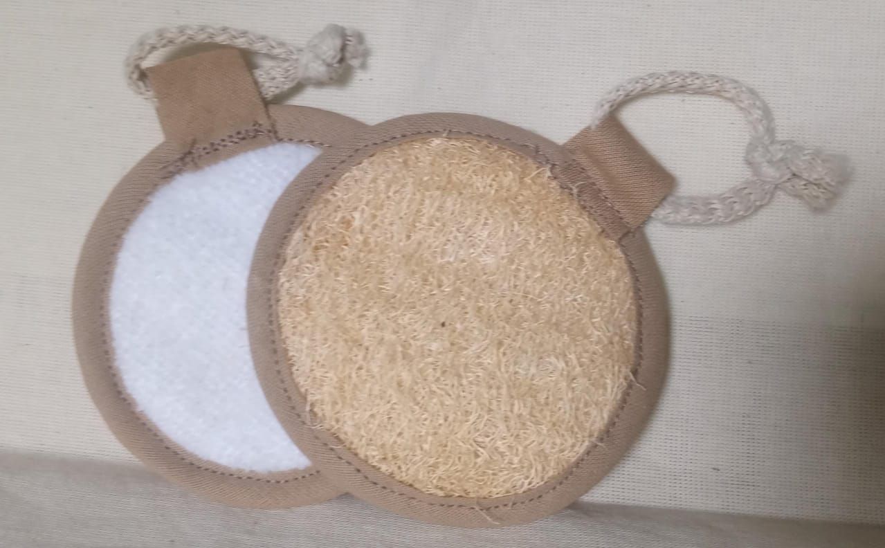 Dos tarros de cosméticos redondos, uno blanco y otro dorado, con lazos de cuerda sobre una superficie beige.
