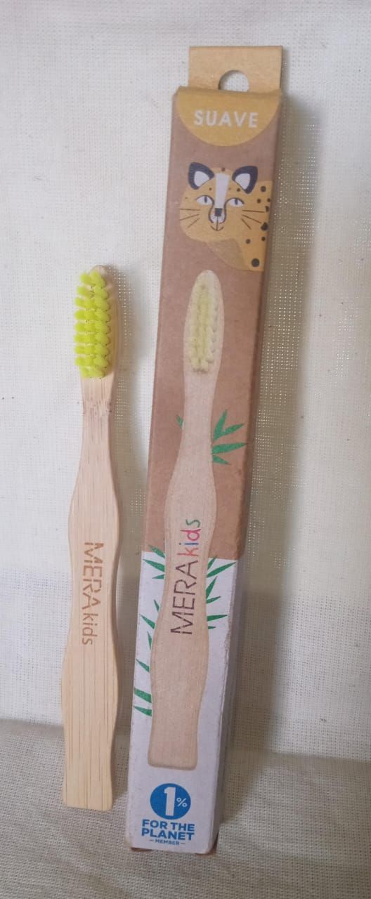 Cepillo de dientes de madera con cerdas moradas en posición vertical sobre un fondo blanco liso.
