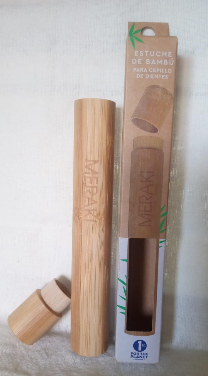 Juego de utensilios de cocina de bambú en su embalaje, con una cuchara de madera y un soporte sobre un fondo blanco.