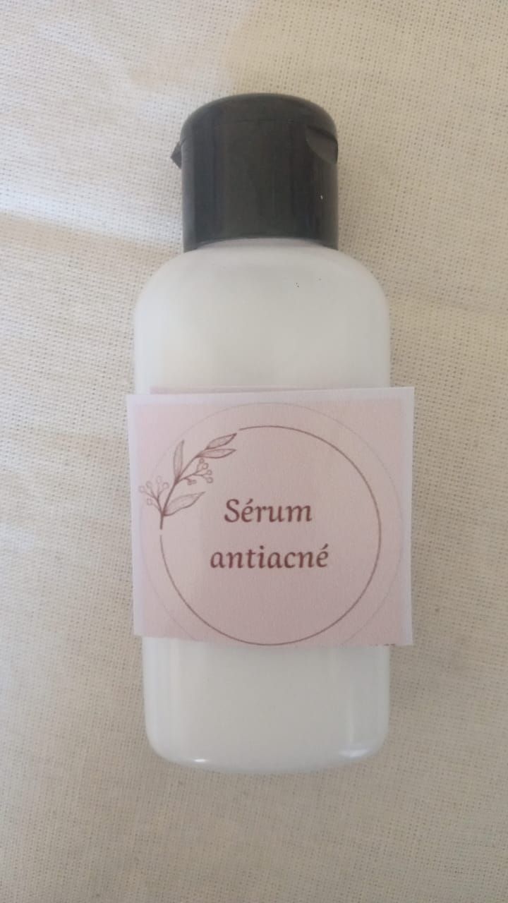 Frasco pequeño esmerilado con tapón negro y etiqueta rosa que dice “Sérum antitox”.