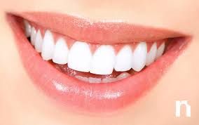 Primer plano de una boca sonriente que muestra dientes blancos brillantes y labios rosados.