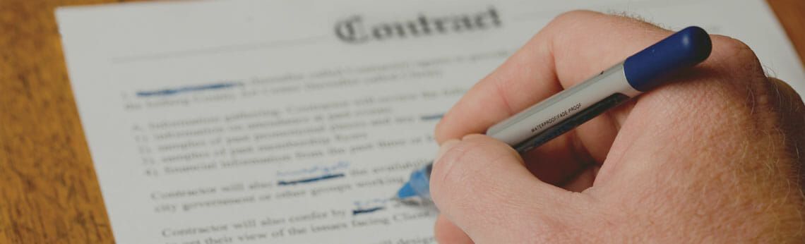 Hand with a blue pen highlighting text on a