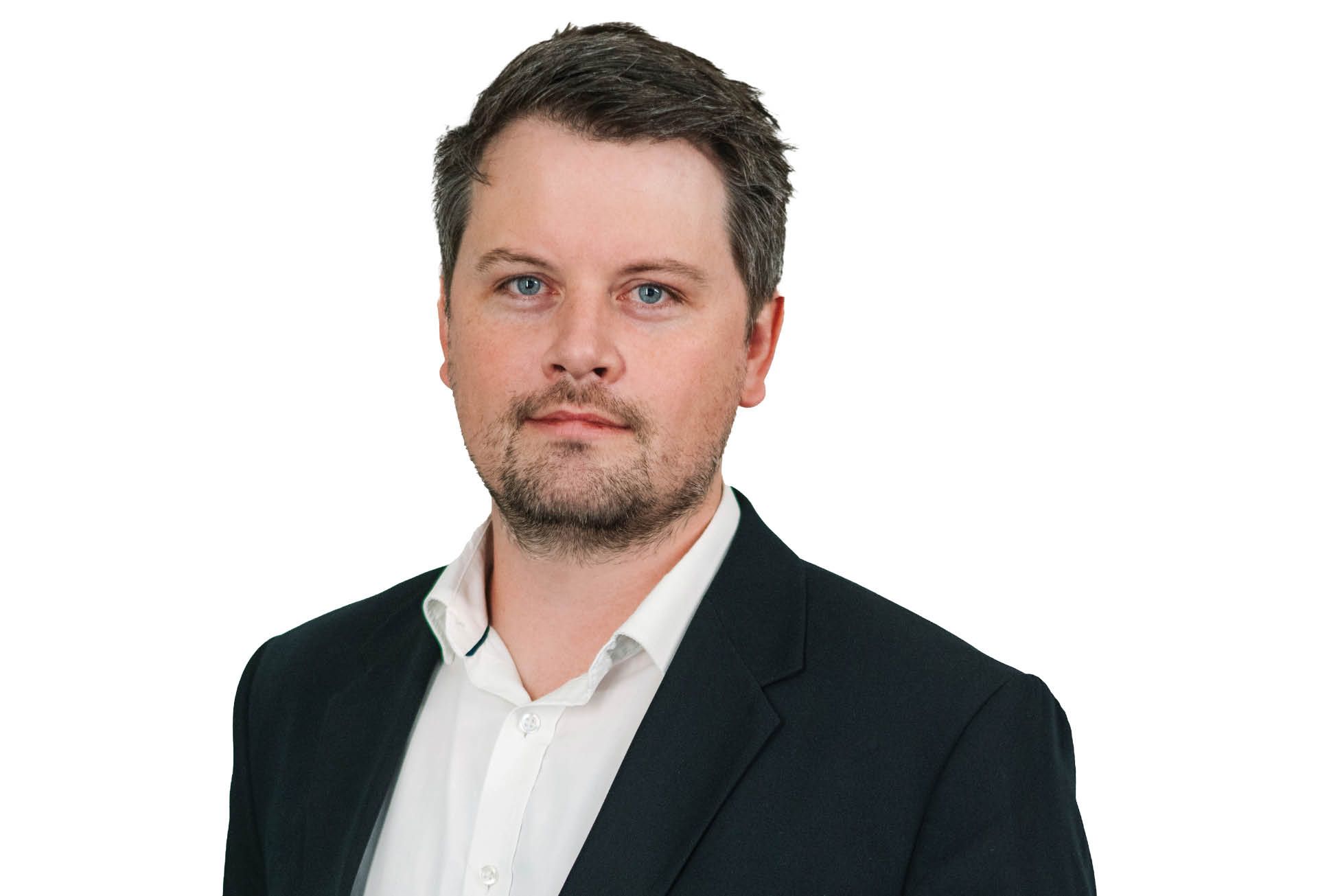 Portrait of a man in a dark blazer and white shirt against a white background