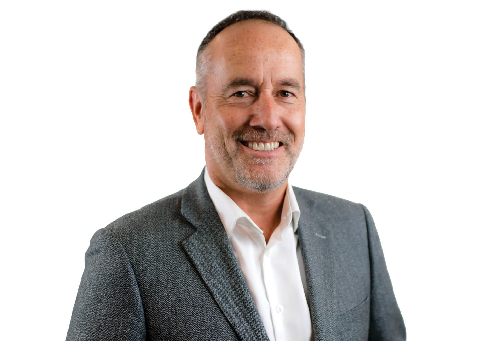 Smiling man in a gray blazer and white shirt against a white background