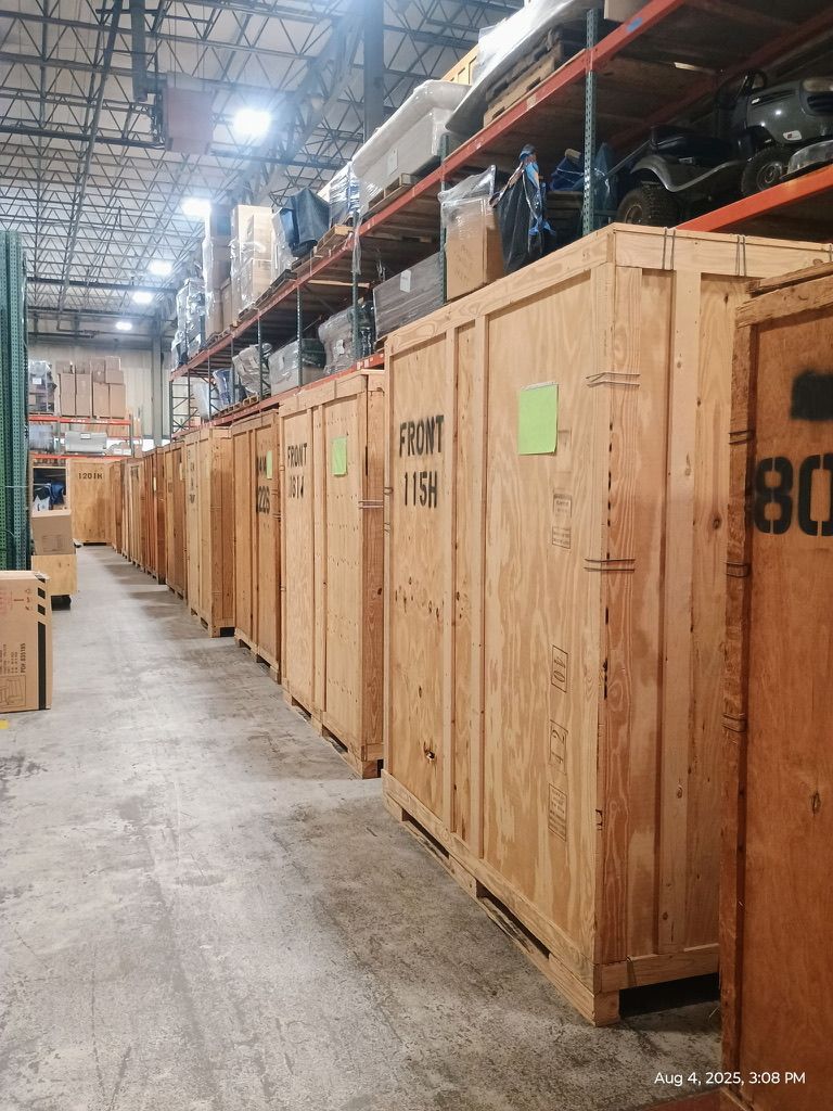 Wooden crates stacked inside a warehouse. Overhead lighting illuminates the rows of containers.