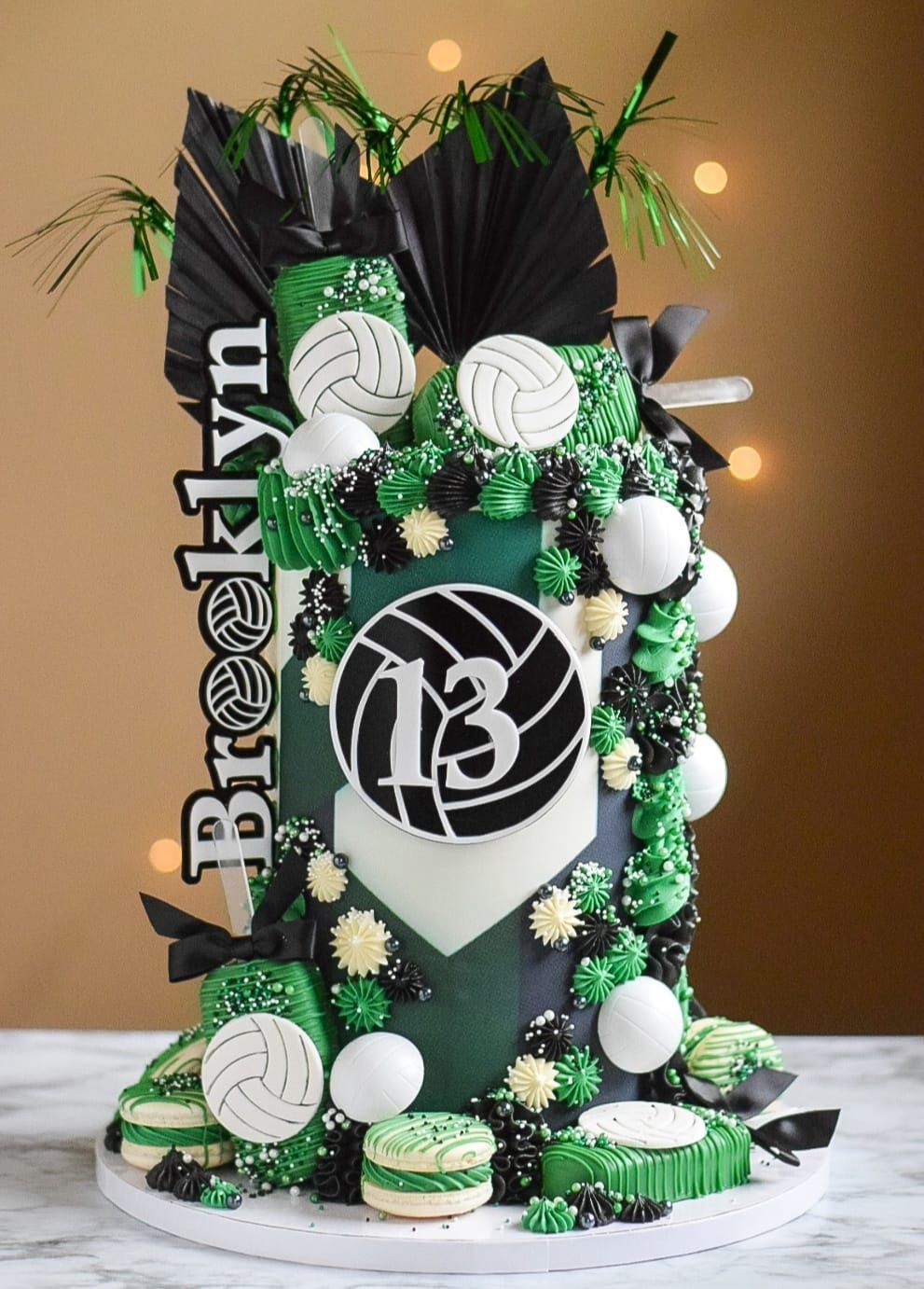 Volleyball-themed cake with green and black frosting, volleyball accents, and 