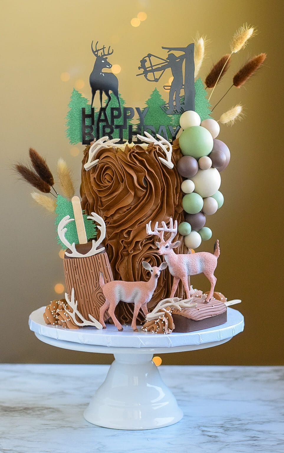Birthday cake with deer, wood-like texture, decorations, and a 