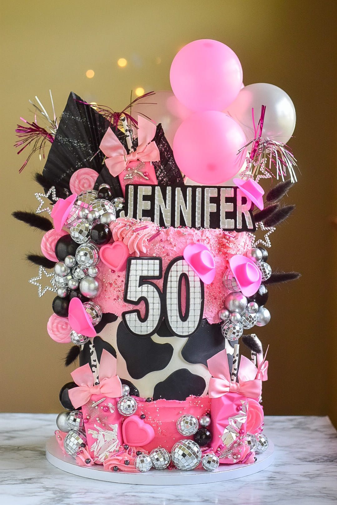 Pink and black cow print birthday cake with 