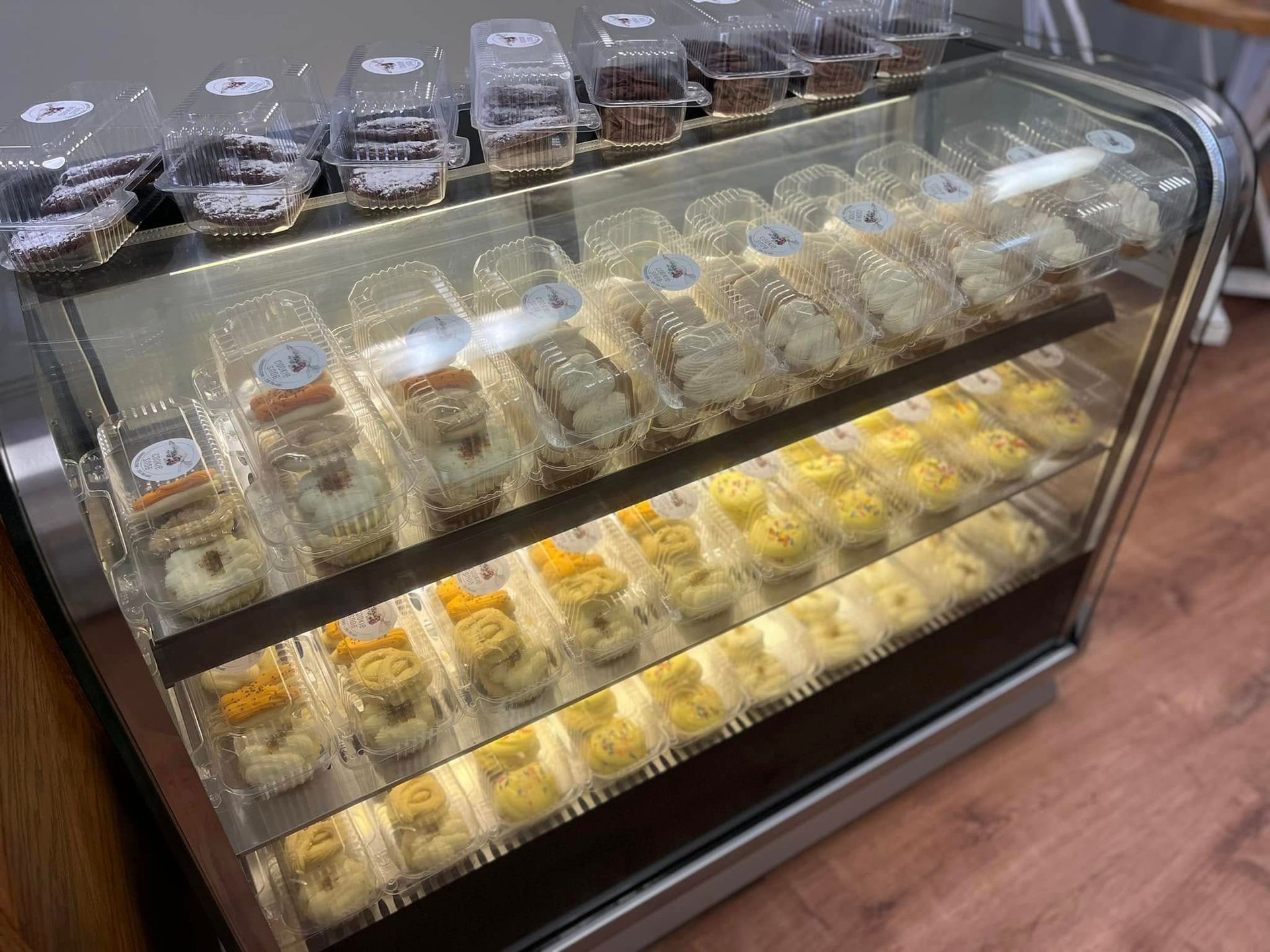 Display case filled with packaged pastries: donuts, cookies, and other baked goods.