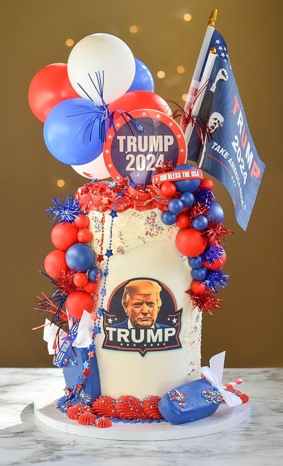 Cake decorated with red, white, and blue balloons, and a 