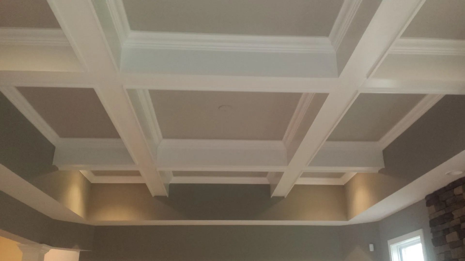 White coffered ceiling with recessed lighting in a living room