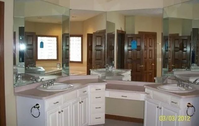 Spacious bathroom vanity with double sinks, large mirrors, and white cabinets