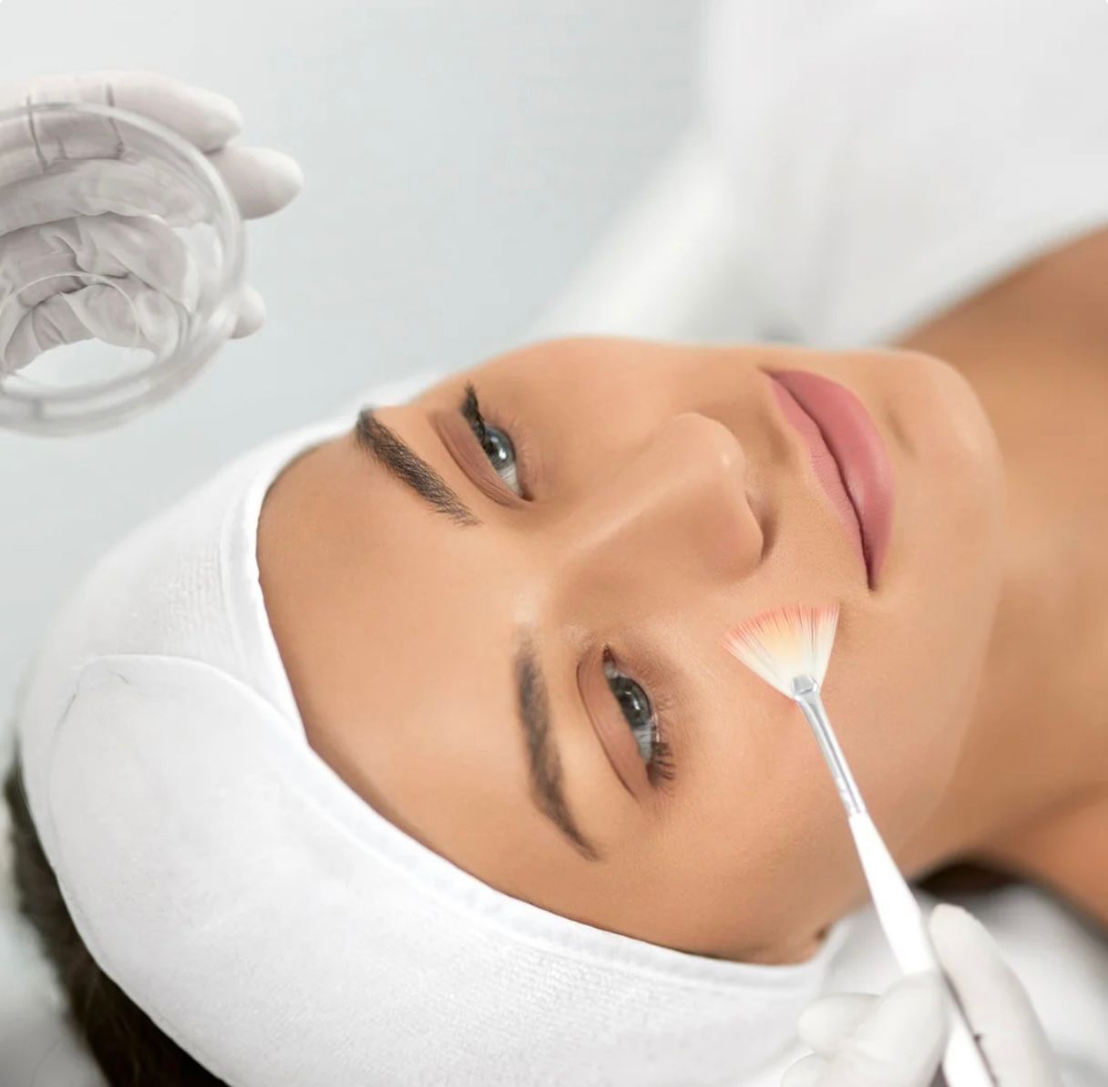 Frau erhält in einem Spa eine Gesichtsbehandlung mit einer Bürste