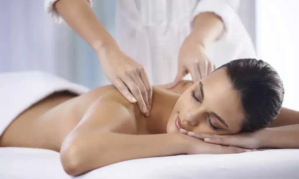 Eine Person, die in einem Spa auf einer Behandlungsliege eine Rückenmassage erhält