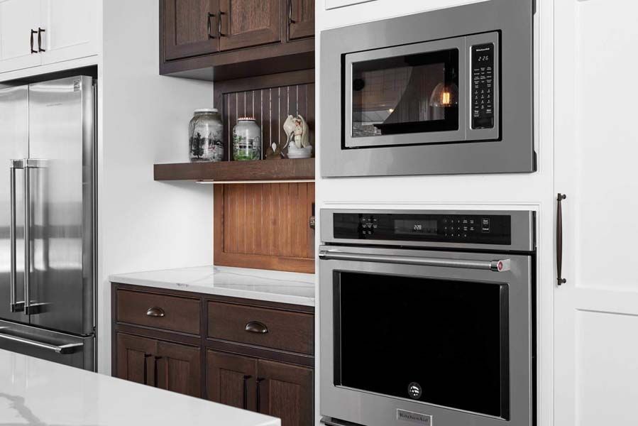 Modern kitchen with stainless steel refrigerator, built-in microwave and oven, and dark wood cabinets