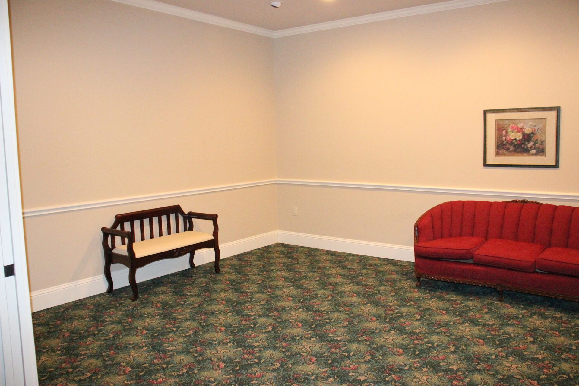 A living room with a red couch and a bench