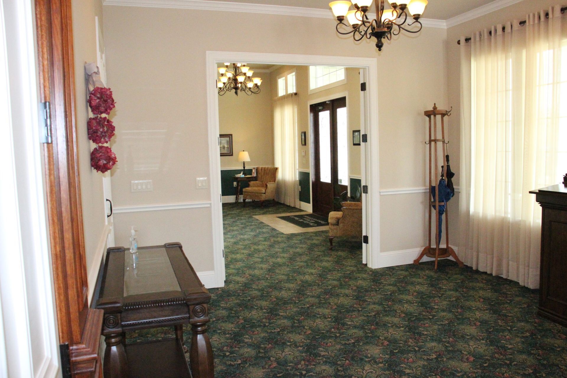 A living room with a table and chairs and a chandelier.