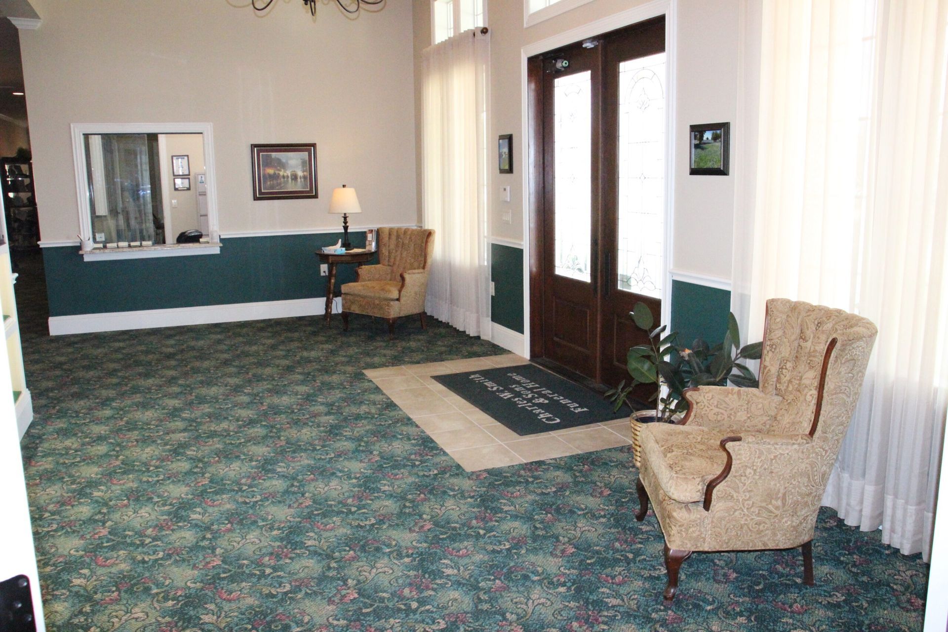There are two chairs in the lobby of a hotel.