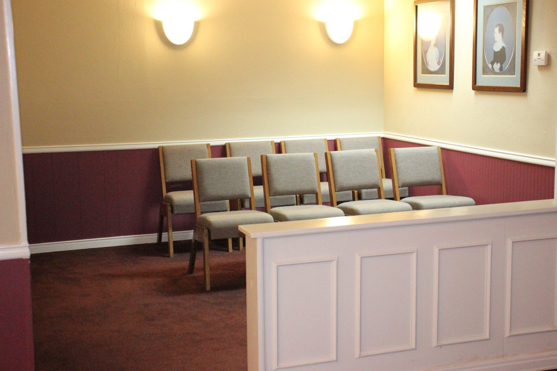 A waiting room with chairs and pictures on the wall