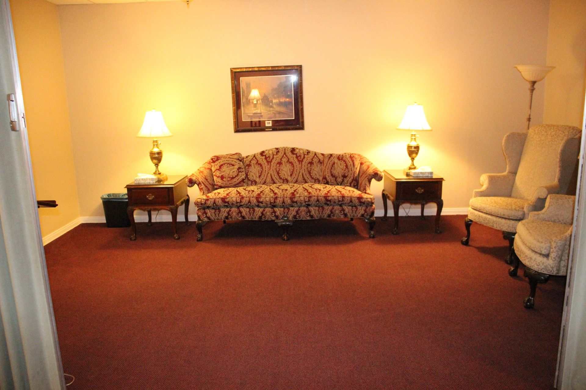 A living room with a couch and two chairs