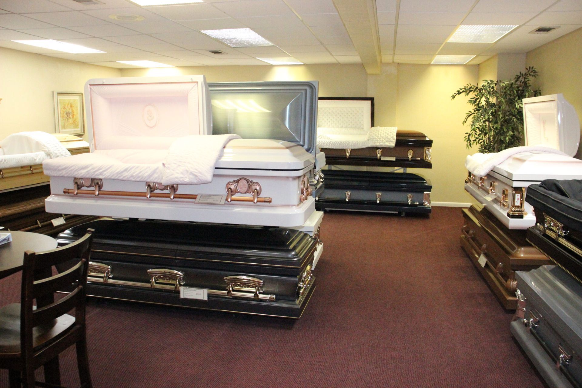 A room filled with lots of coffins including a pink one