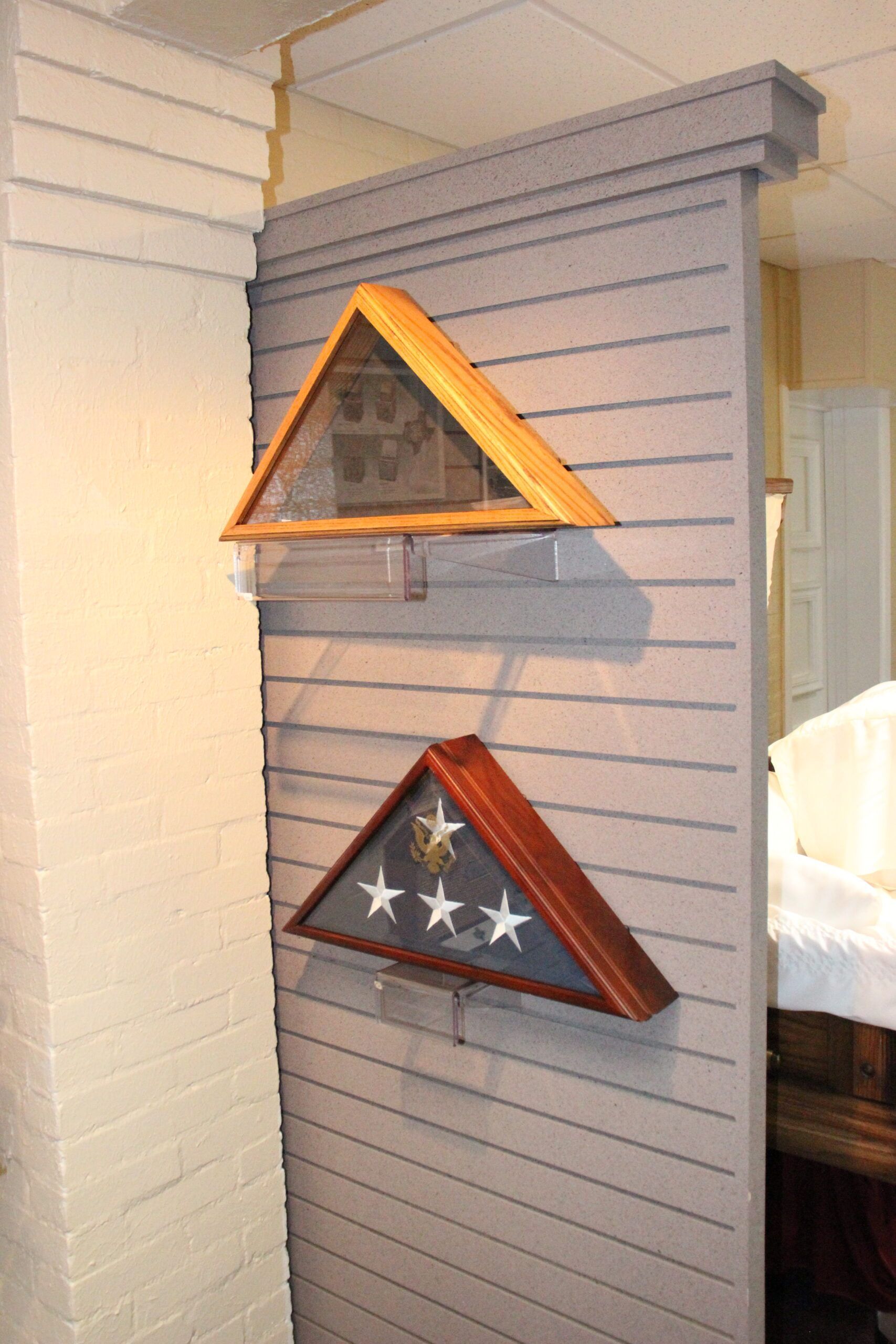 Two flag display cases are hanging on a wall