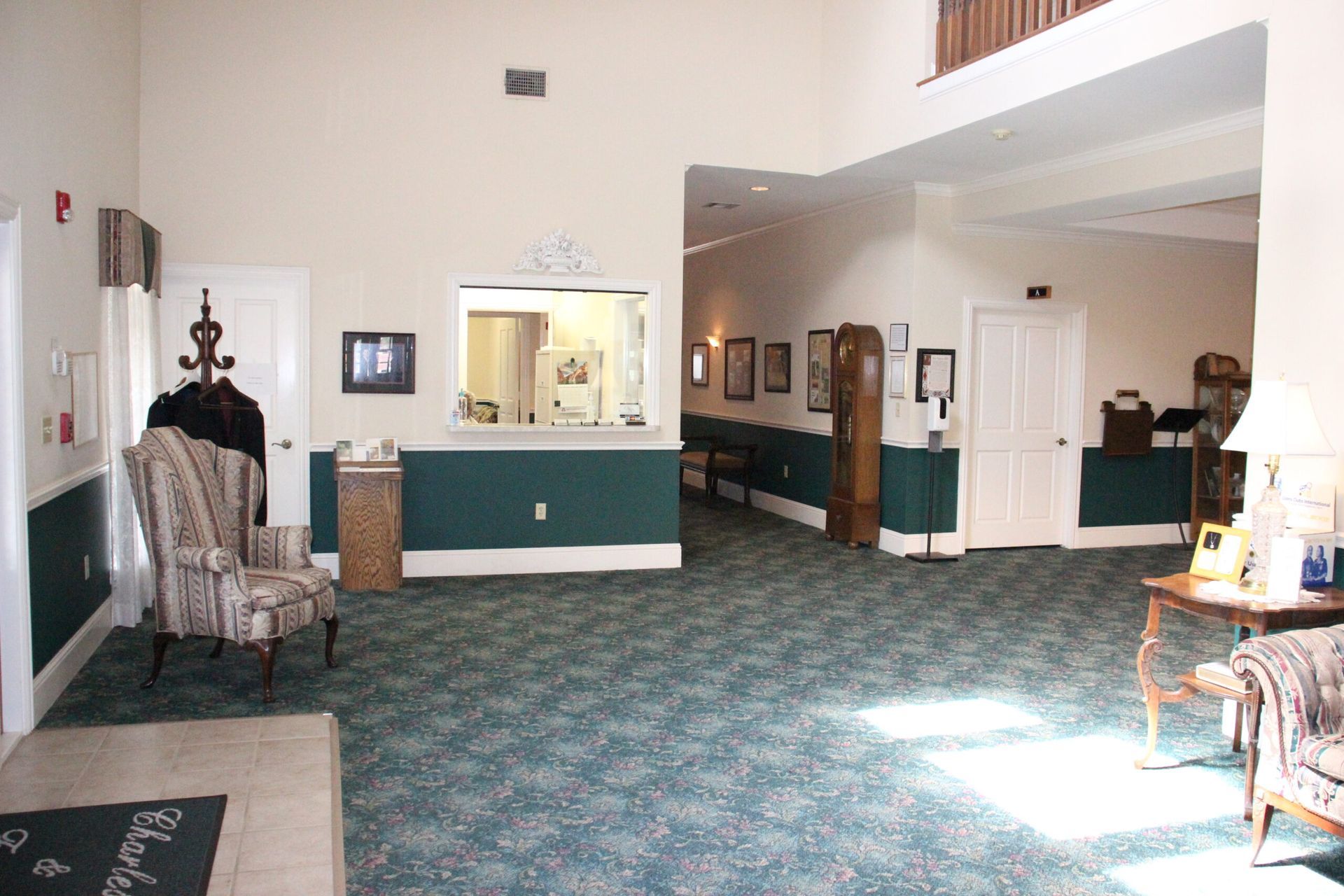A large room with green carpet and white walls