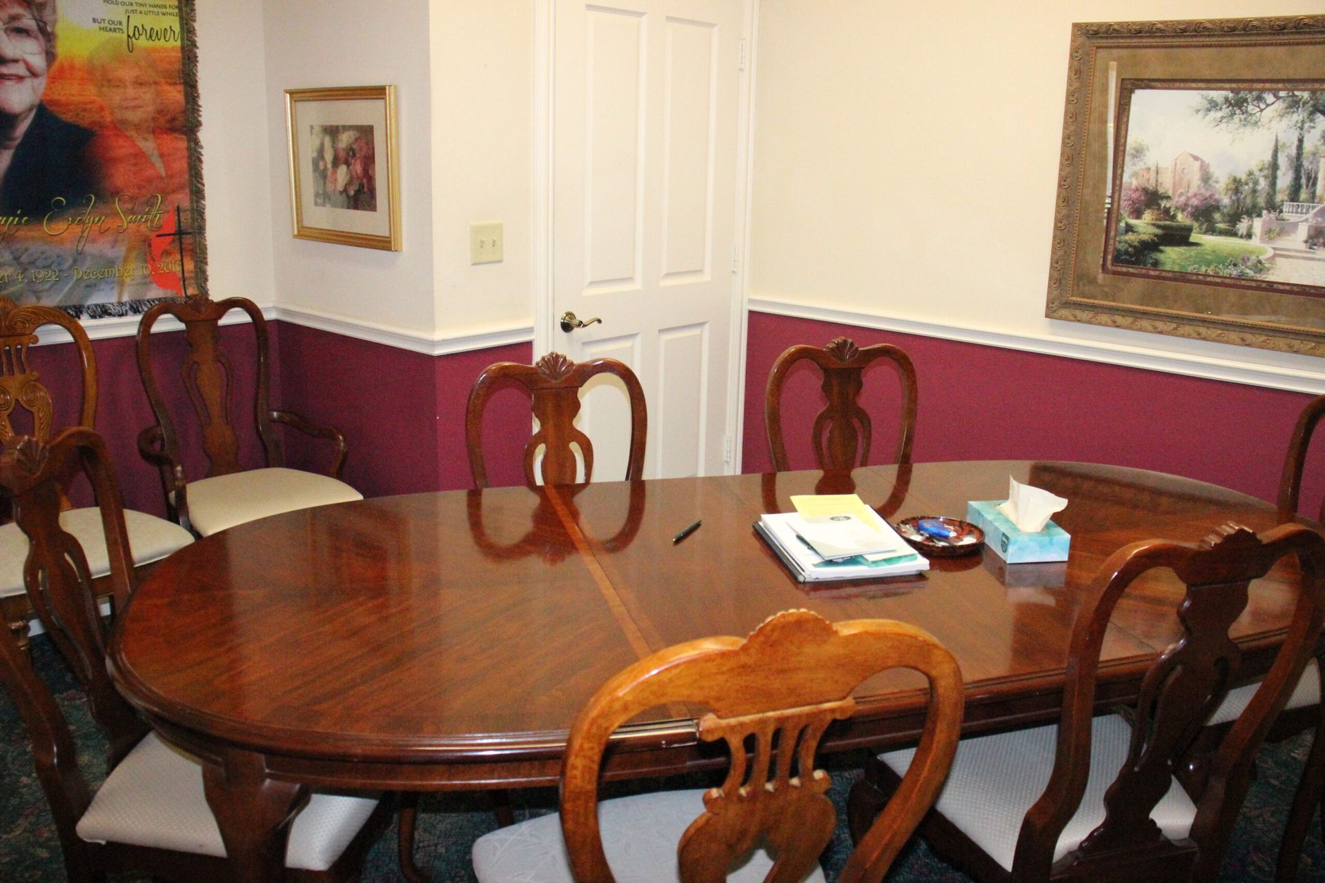 A room with a table and chairs and a painting on the wall