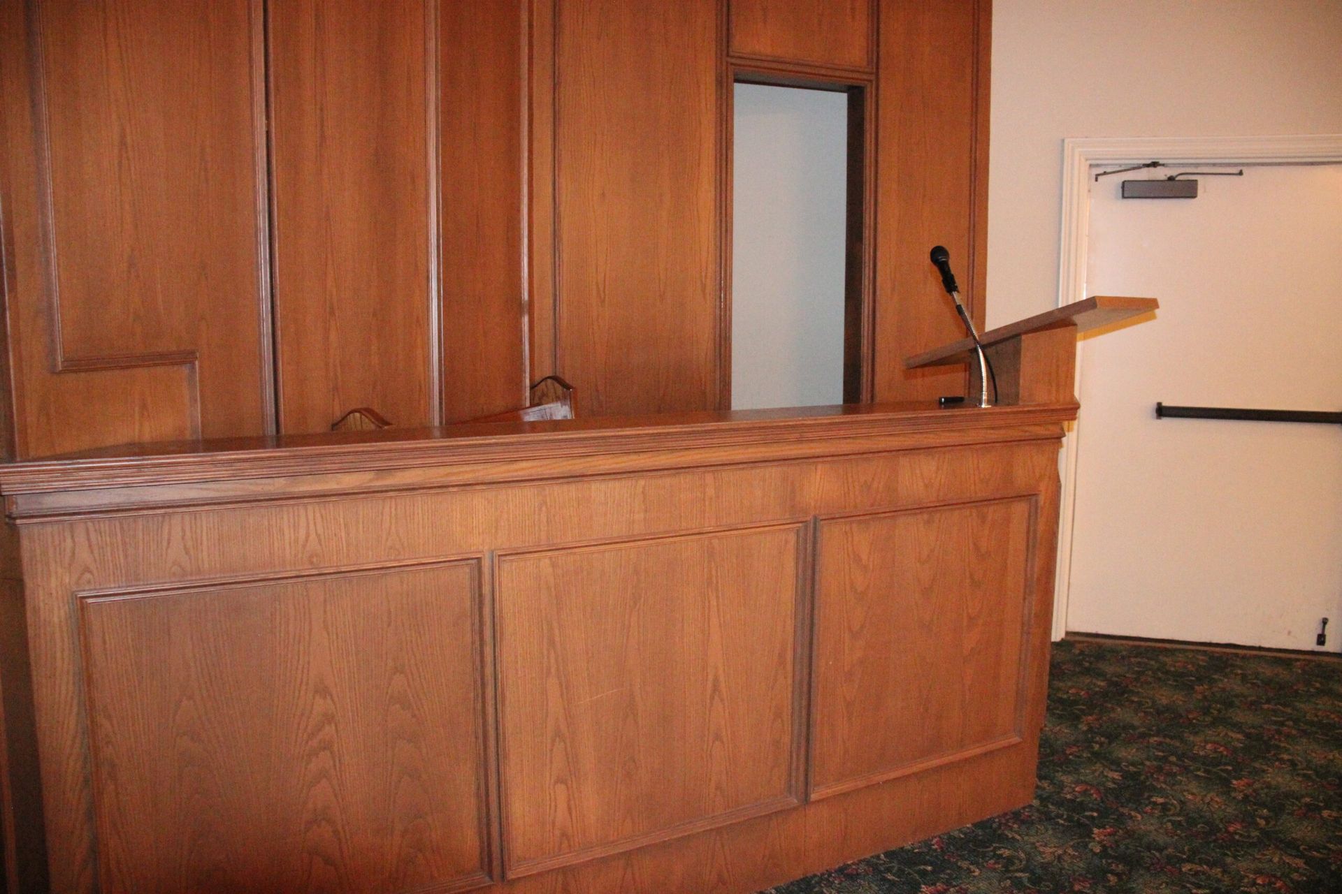 A wooden counter with a podium on top of it in a room.