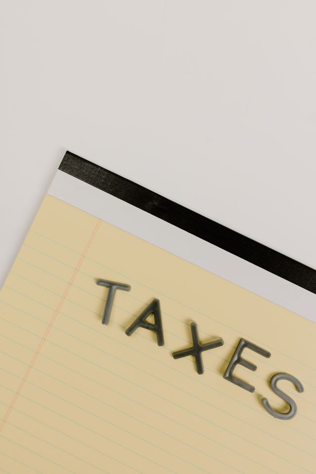 Close-up of a notebook page with the word “TAXES” in bold letters.