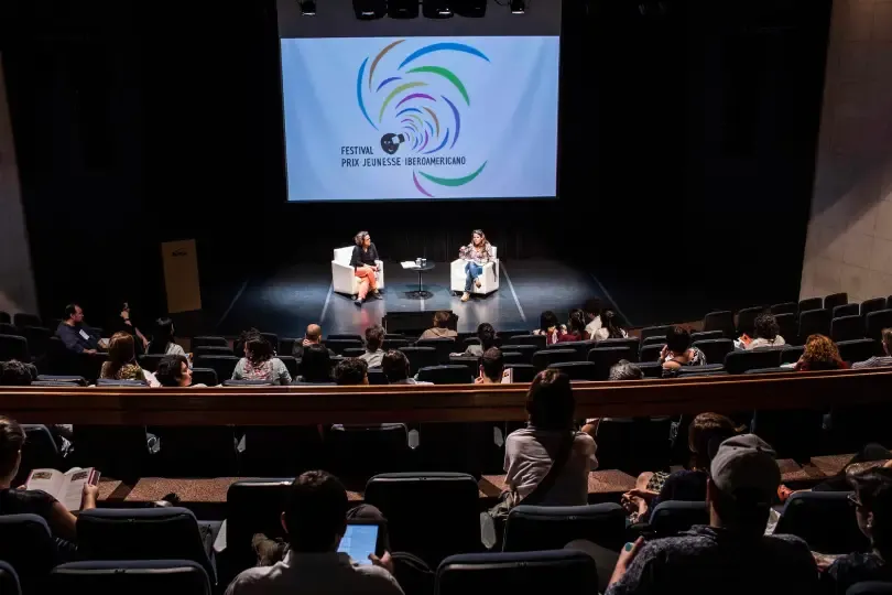 Duas pessoas no palco, em um painel no Festival ComKids