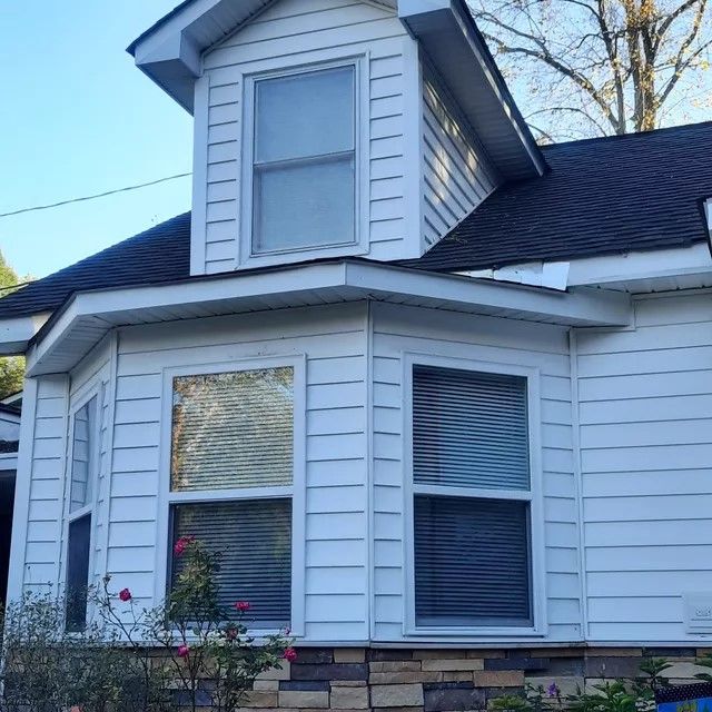 A white house with a black roof and many windows