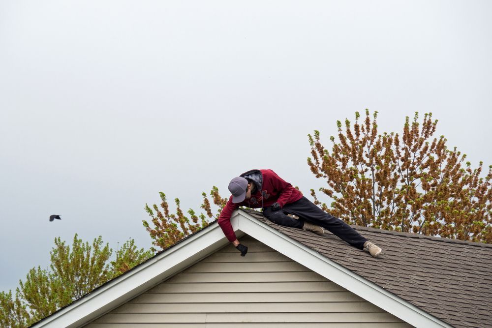 A man is working on the roof of a house.