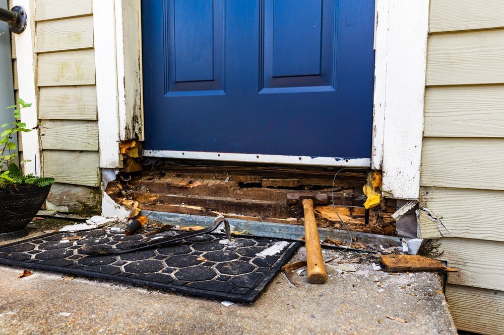 A blue door is being repaired with a hammer.