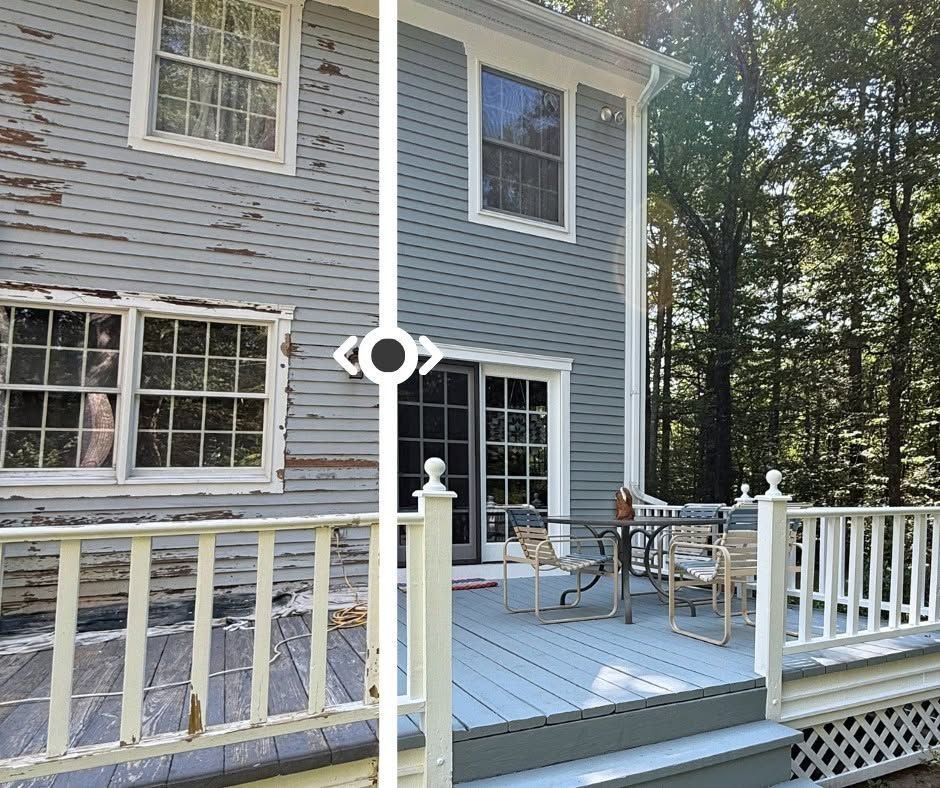 Gray house with white trim and a wooden deck with white railing and patio chairs