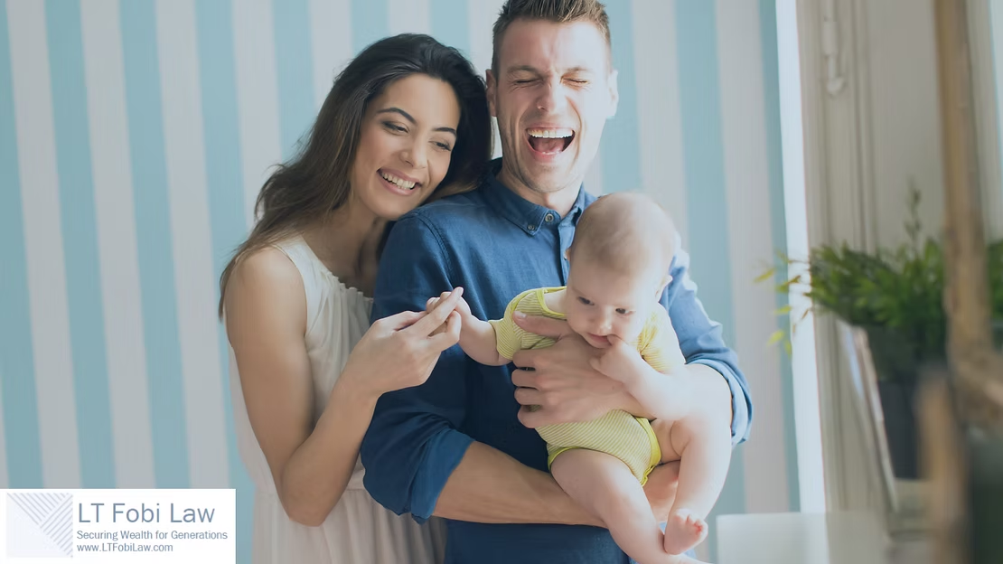 Smiling family holding a baby in a bright nursery with blue striped wallpaper