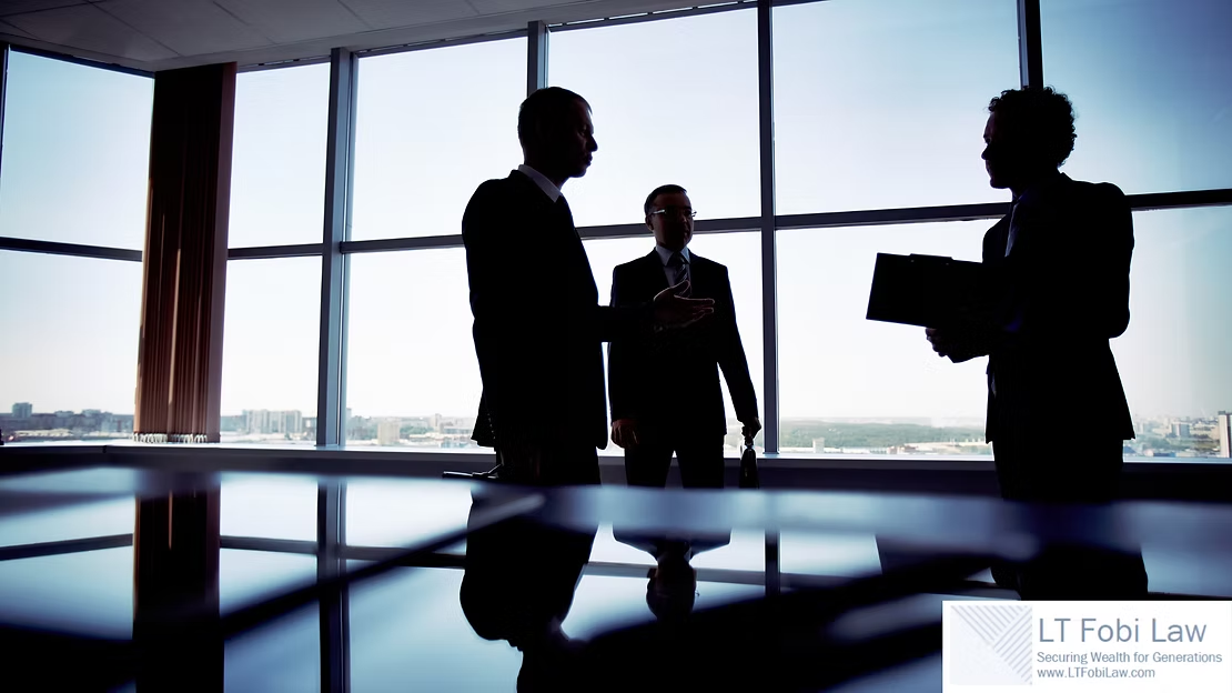 Silhouetted people in a conference room with large windows, standing by a table and discussing business.