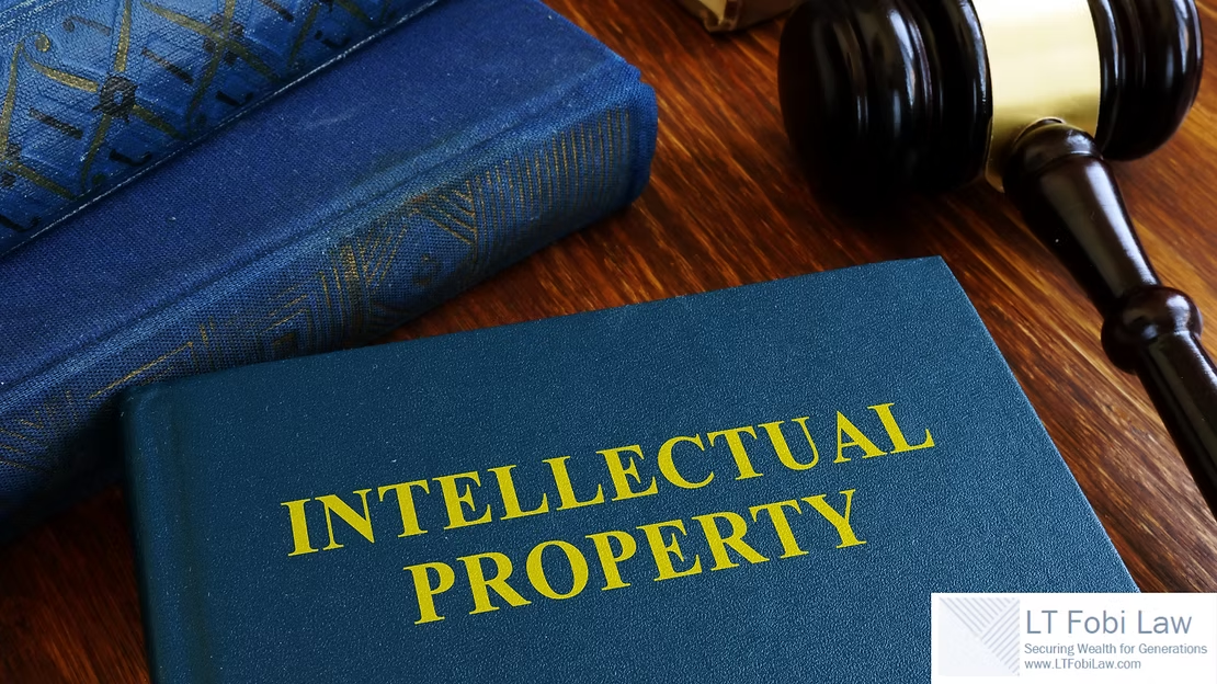 Books labeled “Intellectual Property” beside a gavel on a wooden desk