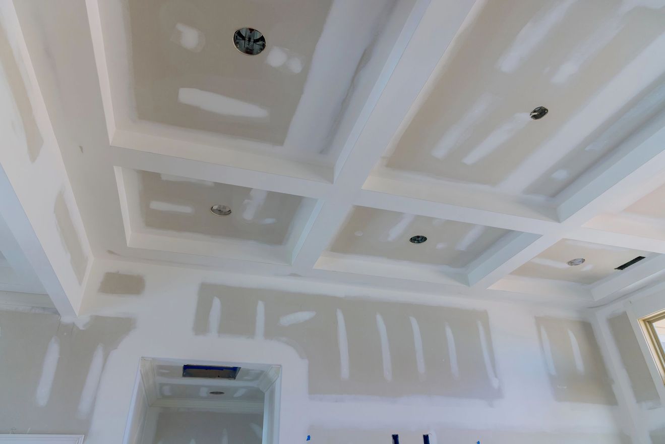 Soffitto con pannelli incassati bianchi e luci incorporate in una stanza in costruzione.
