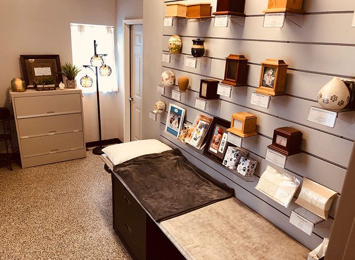 Quiet showroom with shelves displaying boxes, vases, and decor beside a beige dresser and bench.